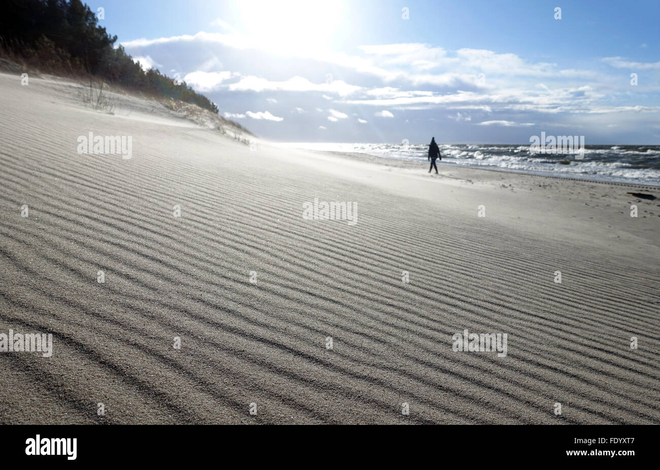 Kolobrzeg, Pologne, la femme s'exécute avec un soleil seul le long de la plage Banque D'Images