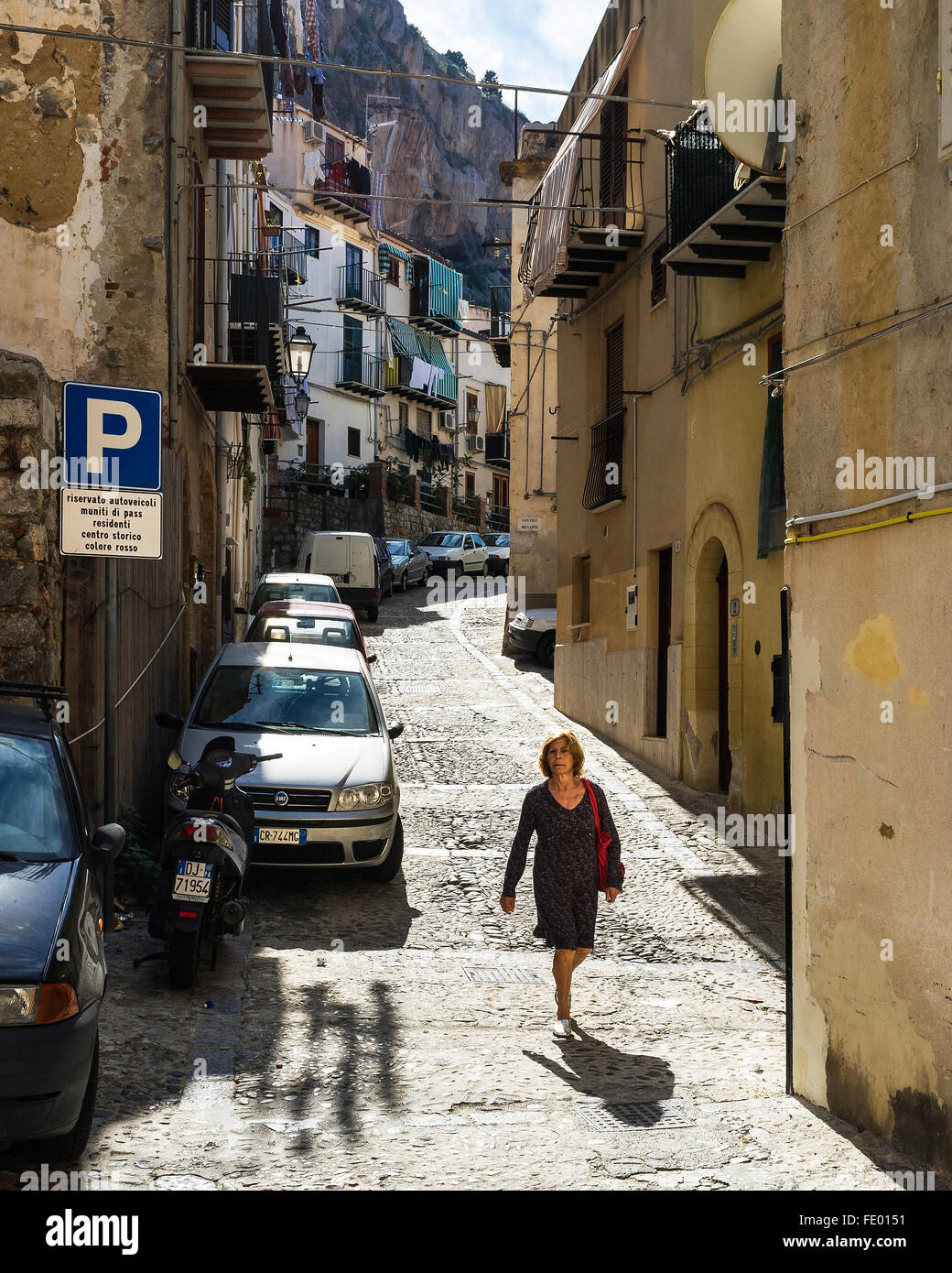 Femme marche dans la rue, ville de Cefalù et commune de la Province de Palerme, Sicile, Italie Banque D'Images