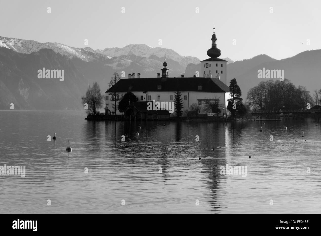 Une image en noir et blanc de Schloss ort à Gmunden, en Autriche, avec des montagnes enneigées en arrière-plan Banque D'Images
