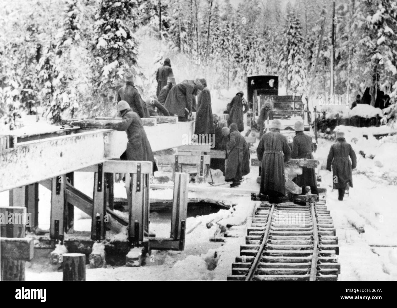 Le tableau de la propagande nazie montre la construction du Heeresfeldbahn (chemin de fer de campagne militaire allemand) à travers l'Organisation Todt sur le front oriental. La photo a été prise en février 1943. Le texte de propagande nazie au dos de la photo se lit comme suit: 'Les hommes et les anciens membres de l'Organisation Todt construisent le plus long chemin de fer léger de l'est dans la jungle de Karelian. Une voie supplémentaire est située à côté du pont en construction afin que le matériau puisse être transporté sur le lieu de travail. » Fotoarchiv für Zeitgeschichtee - PAS DE SERVICE DE VIREMENT - Banque D'Images