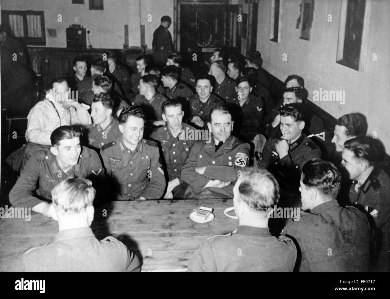 Le tableau de la propagande nazie montre le ministre de l'armement et de la production de guerre Albert Speer (avec le brassard de la swastika) entre les soldats de la Wehrmacht allemande dans un logement militaire sur le front polaire. La photo a été prise en février 1944. Fotoarchiv für Zeitgeschichtee - PAS DE SERVICE DE VIREMENT - Banque D'Images