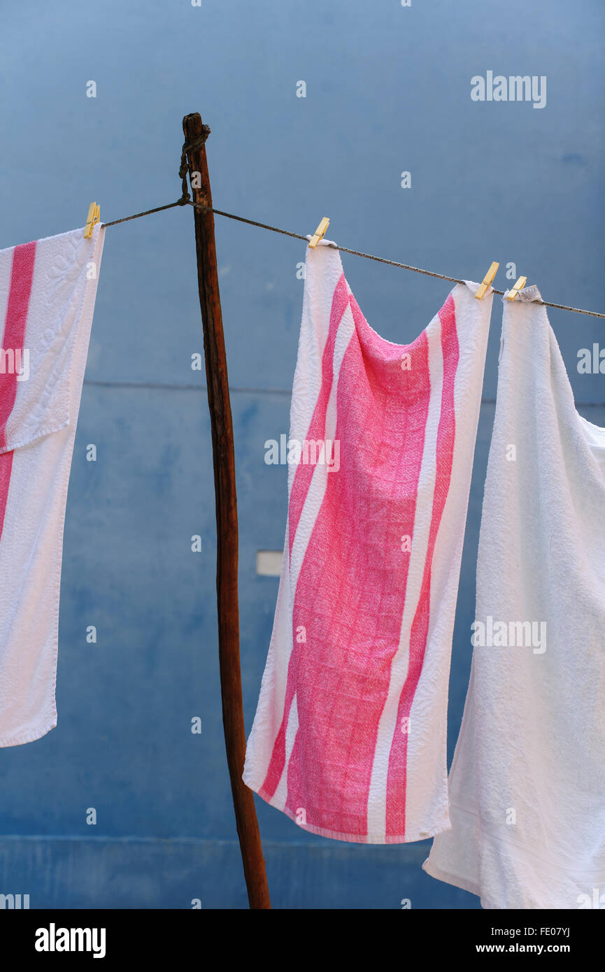 Torchons rose et blanc contre un mur bleu Banque D'Images