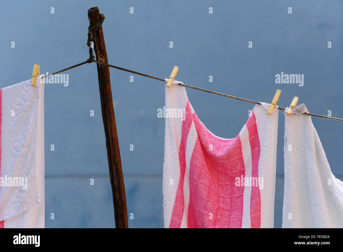 Torchons rose et blanc contre un mur bleu Banque D'Images