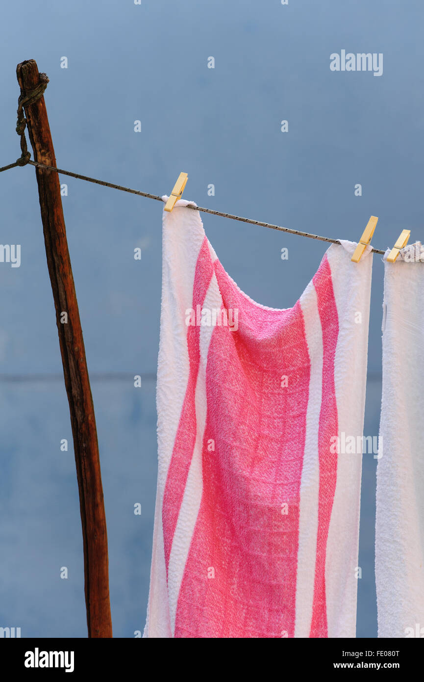 Torchons rose et blanc contre un mur bleu Banque D'Images