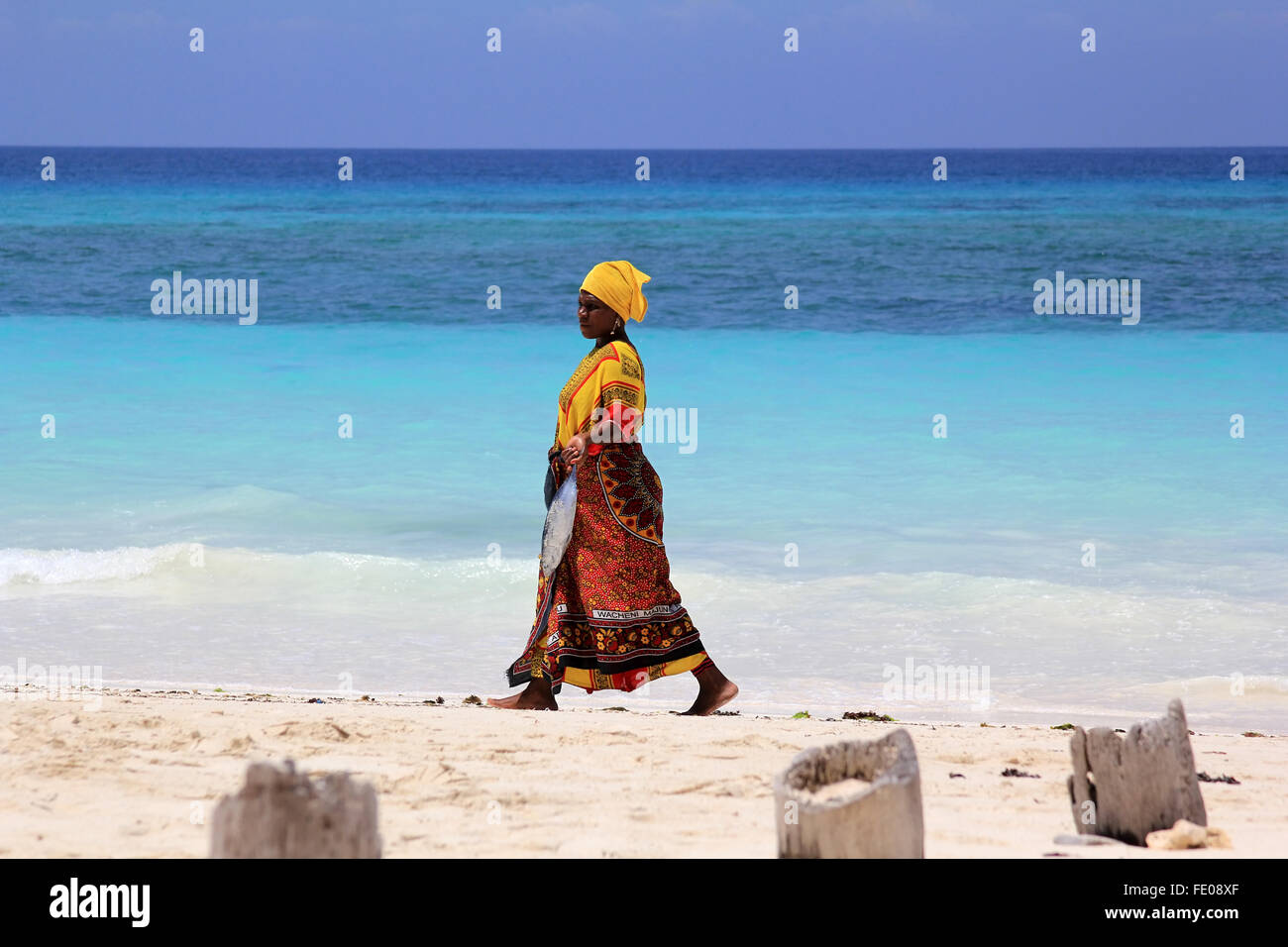 Zanzibar, Tanzanie - 7 janvier 2016 : une femme africaine en tenue  traditionnelle avec des poissons marche le long de la plage. Zanzibar,  Tanzanie Photo Stock - Alamy