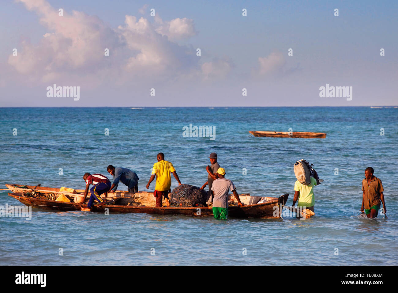 Un dhow traditionnel (voilier) dans l'arrière-plan et un bateau de pêche et fishman au premier plan dans l'Océan Indien Banque D'Images