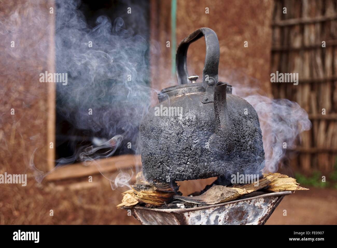 Un pot noirci électrique assis sur un petit feu soulevées à ébullition. Banque D'Images