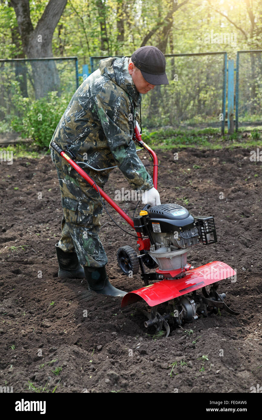 Homme travaillant dans le jardin la préparation de sol cultivateur Banque D'Images