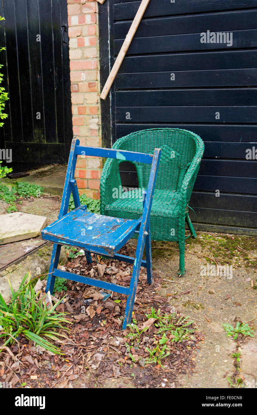 Deux chaises abandonnées à l'extérieur faisant l'objet d'un garage. Banque D'Images