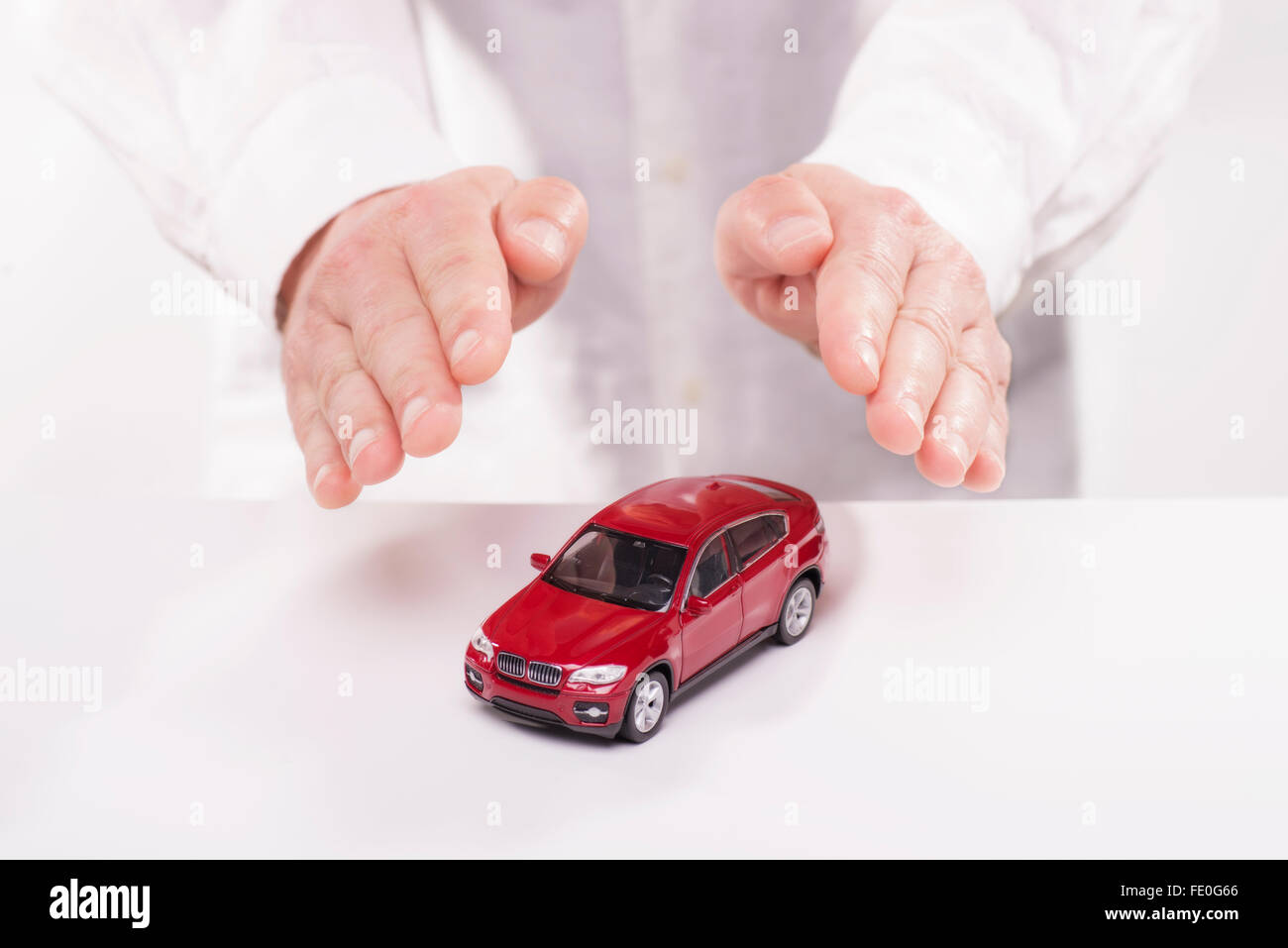 Les mains sont tenues de manière protectrice sur une voiture. Banque D'Images