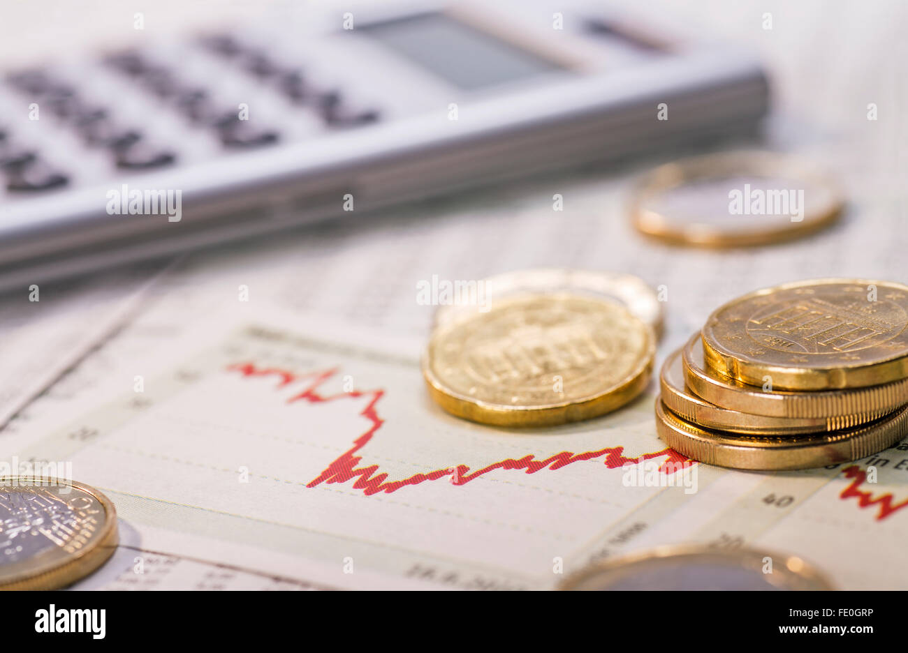 Pièces en euros et un graphique avec courbe rouge symbolisant la fluctuation des taux de change. Banque D'Images