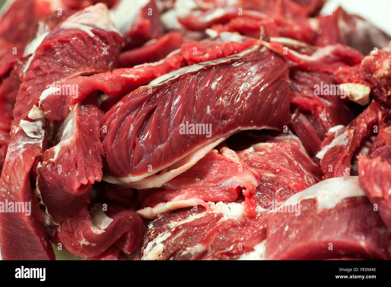 Close up of sections fraîchement coupées de boeuf rouge avec des morceaux de graisse blanche pour l'usine de traitement de la viande Banque D'Images