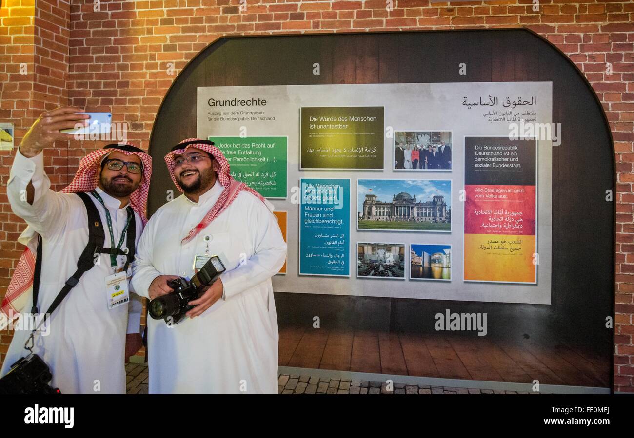 Riyadh, Arabie saoudite. 3, 2016. Deux hommes l'Arabie prend une dans le pavillon allemand selfies en face d'un homme de base, de l'affiche à l'Jenadriyah Festival à Riyadh, Arabie saoudite, 3 février 2016. L'Allemagne est le pays invité à la 2 semaines et folk festival culturel près de Riyad. Photo : MICHAEL KAPPELER/dpa/Alamy Live News Banque D'Images