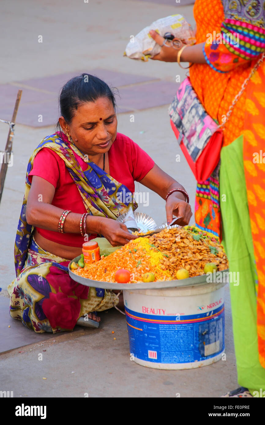 Femme vendant de la nourriture par l'homme Sagar Lake à Jaipur, Rajasthan, Inde. Banque D'Images