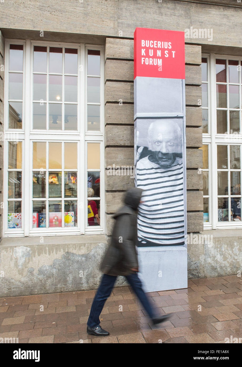 Hambourg, Allemagne. 1er février, 2016. Un homme marche par une bannière annonçant l'exposition Picasso à l'extérieur de la Bucerius Kunst Forum (Bucerius forum art) à Hambourg, Allemagne, 1 février 2016. L'exposition, Picasso. Fenster zur Welt (lit. Picasso. Fenêtre sur le monde), se déroule du 06 février au 16 mai 2016 au Forum. PHOTO : LUKAS SCHULZE/DPA/Alamy Live News Banque D'Images