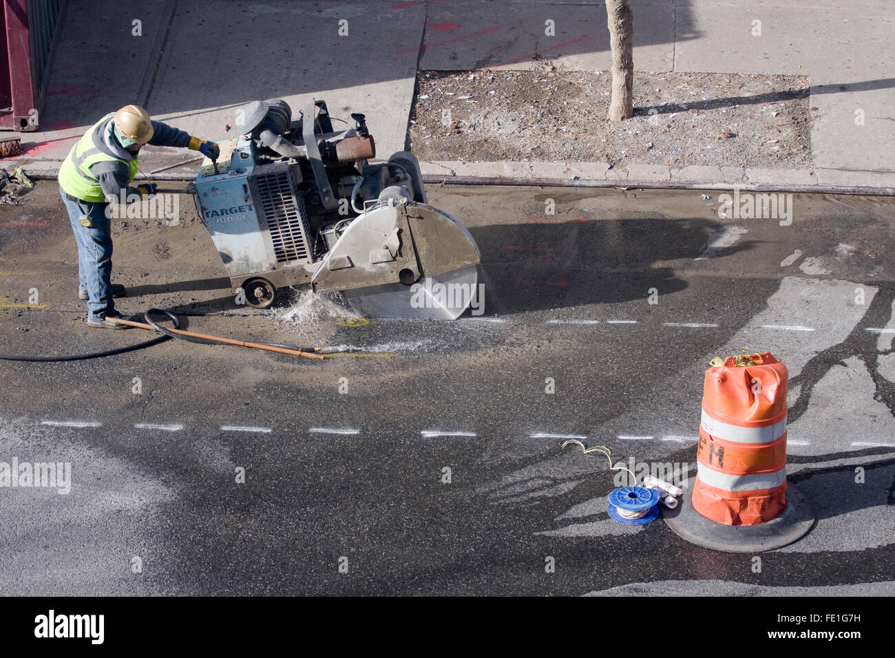 Travailleur de la construction d'une cible d'exploitation Pro66 grand diamètre automoteur maçonnerie sur une rue de la ville Banque D'Images