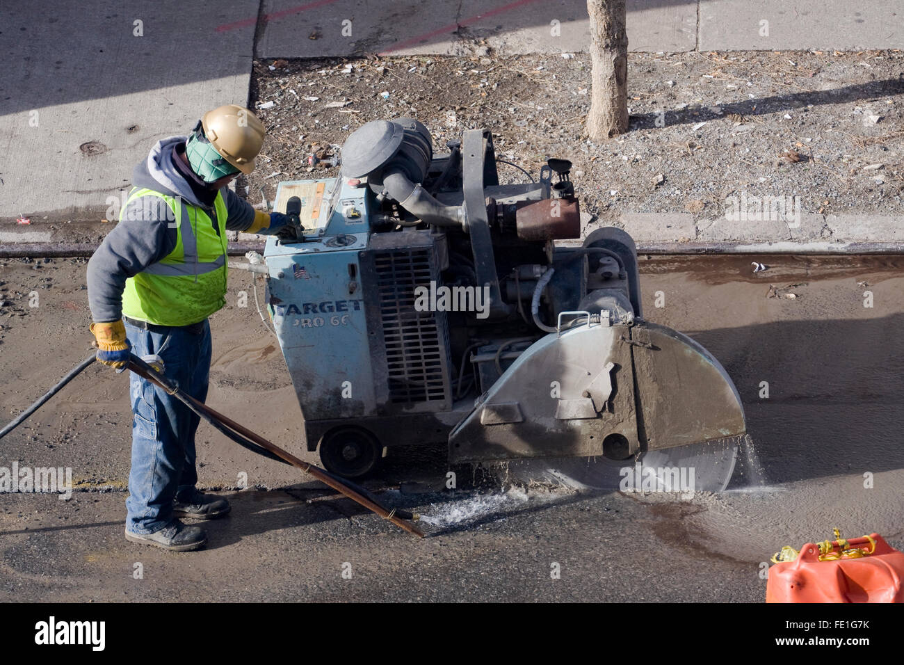 Travailleur de la construction d'une cible d'exploitation Pro66 grand diamètre automoteur maçonnerie sur une rue de la ville Banque D'Images