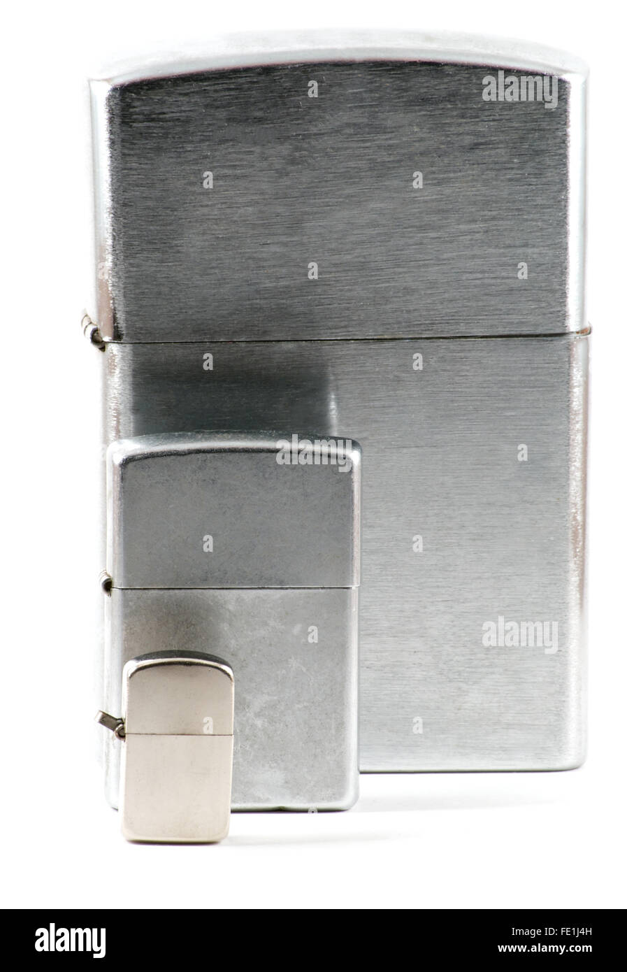 Trois tailles différentes de briquets avec capuchon métallique fermé sur fond blanc Banque D'Images