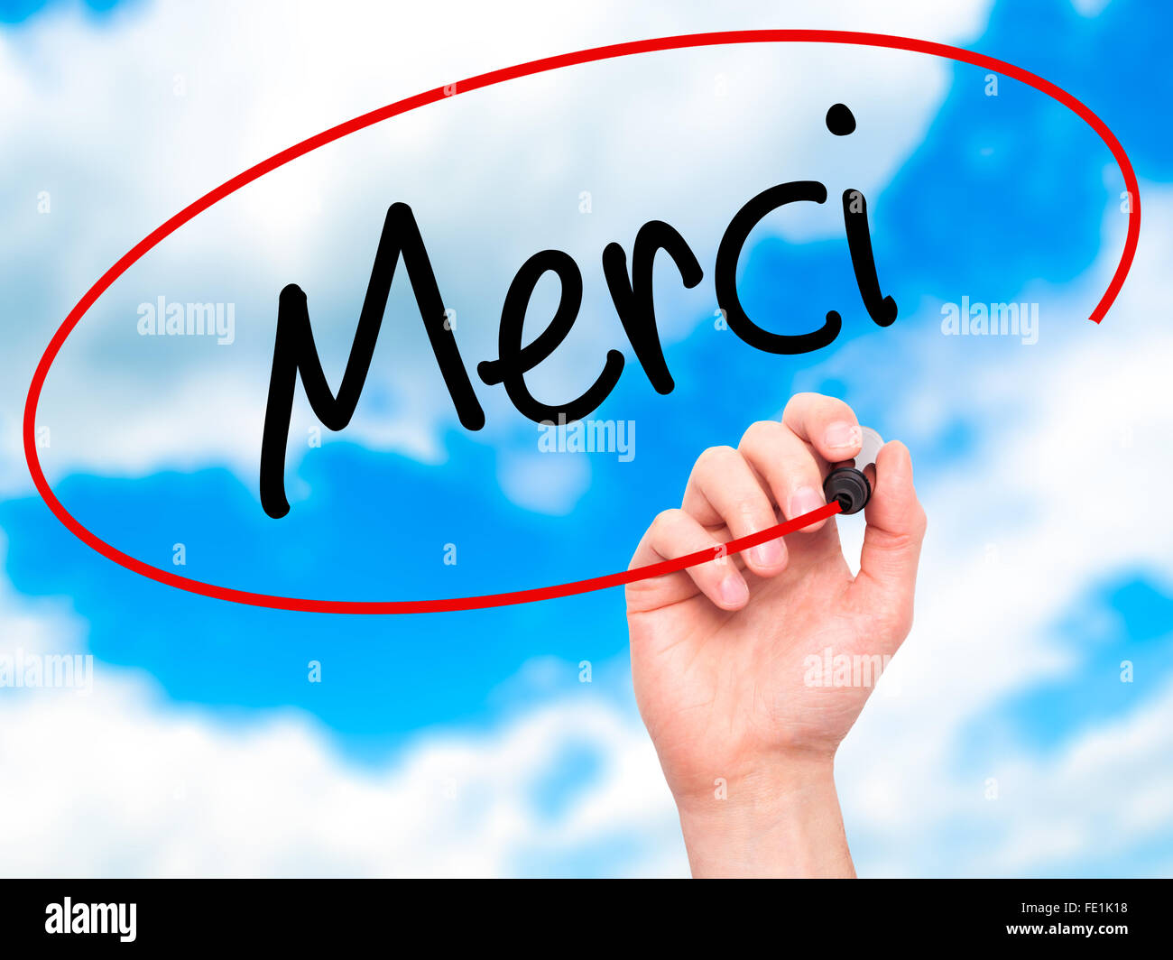 Man main écrit Merci (Merci en français) avec marqueur noir sur l'écran visuel. Isolé sur fond. Affaires, de la technologie, Banque D'Images