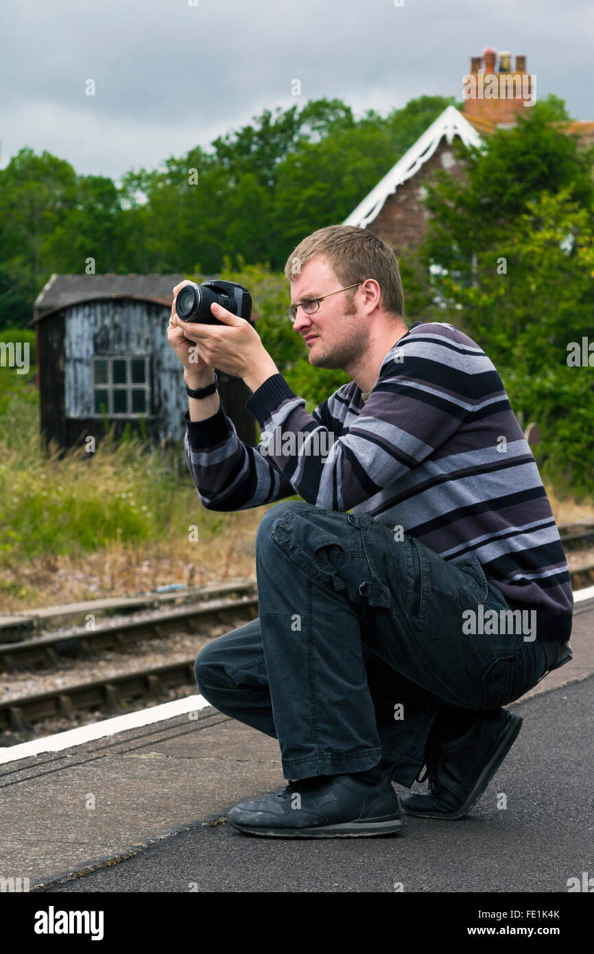 L'homme de prendre des photos de trains à vapeur à Watchet Station sur la West Somerset Railway, UK Banque D'Images