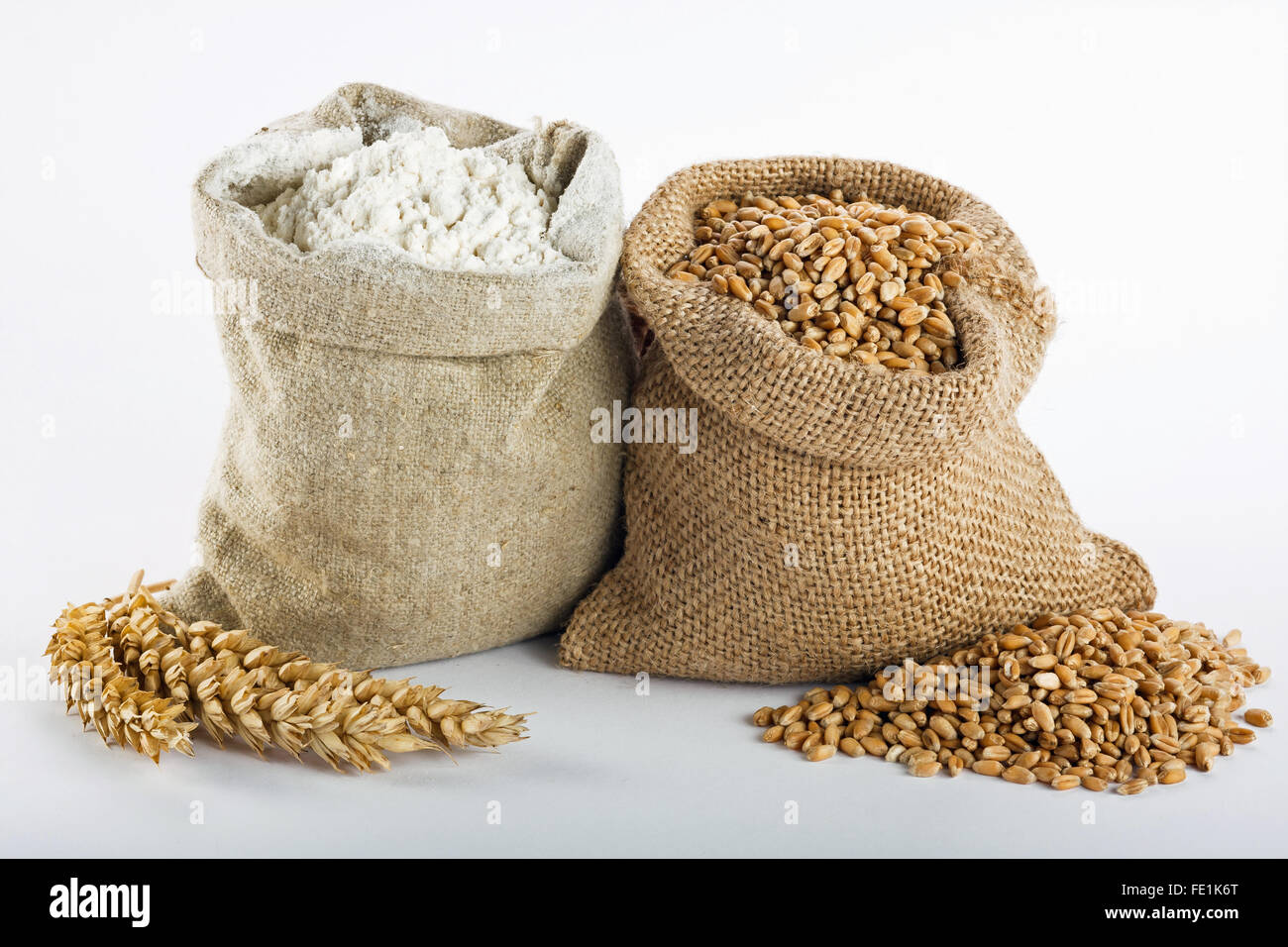 La farine et le grain de blé dans de petits sacs de toile Banque D'Images