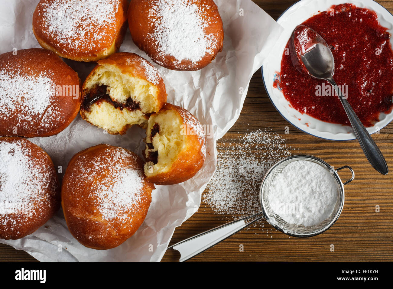 Beignets faits maison remplie de marmelade rose sur table en bois. Banque D'Images