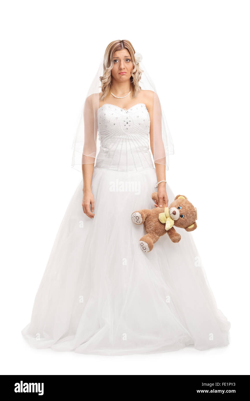 Portrait d'une jeune mariée triste holding a teddy bear et regardant la caméra isolé sur fond blanc Banque D'Images