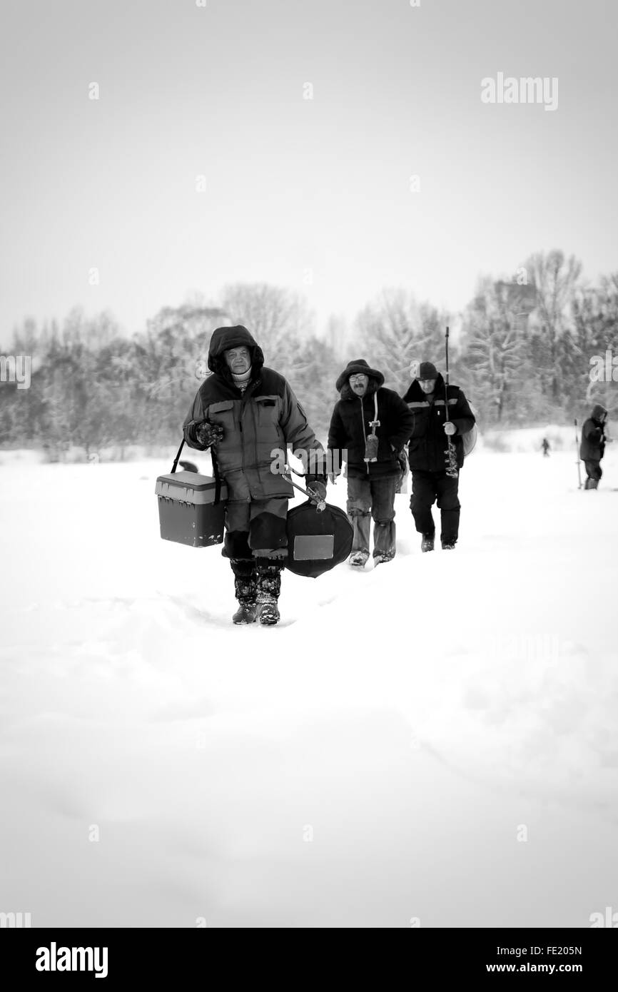 URussian les pêcheurs à pied sur la rivière Belaya 'white' de se préparer pour la pêche sur glace à l'aide de vis sans fin Banque D'Images