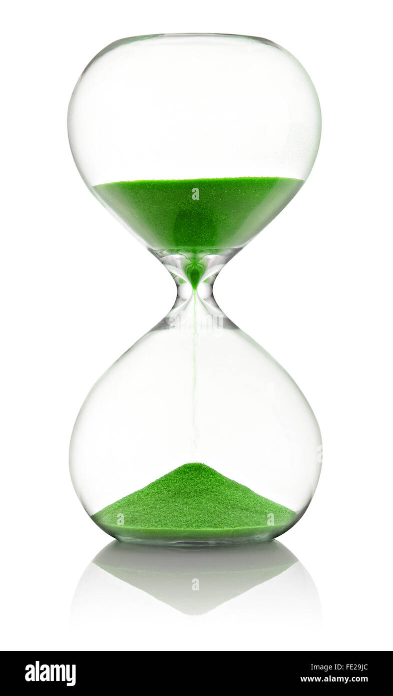 Sablier en verre avec du sable vert qui traverse la mesure de temps qui passe dans un compte à rebours jusqu'à une date limite, plus de blanc avec reflet Banque D'Images