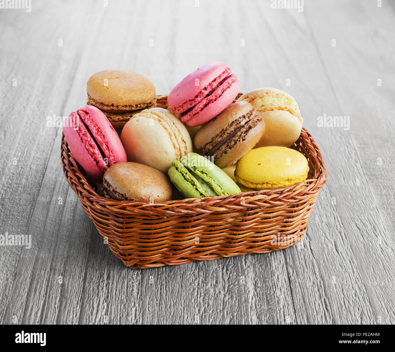 Colorés et savoureux macarons français sur le panier en osier Banque D'Images