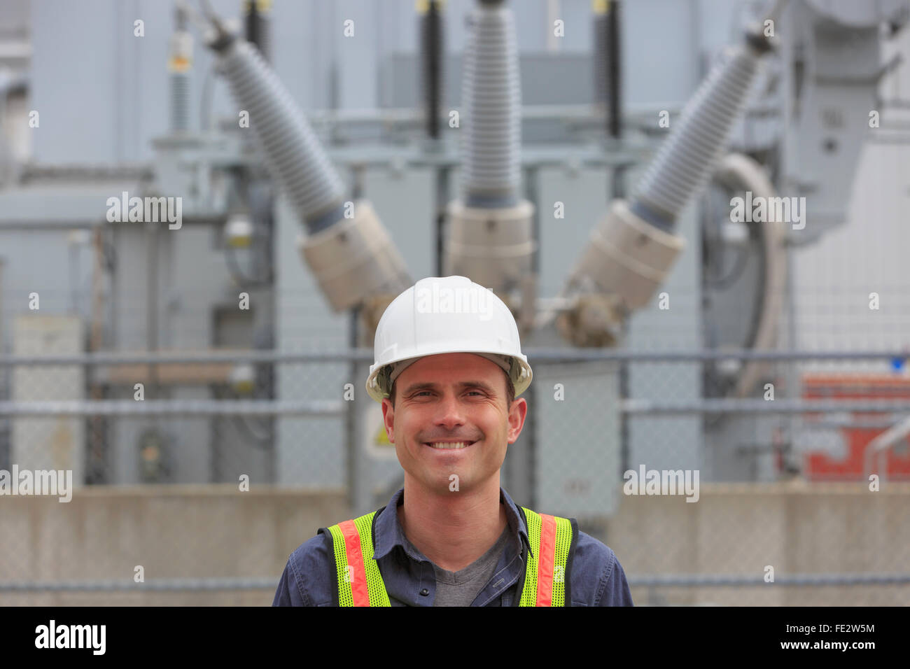 Ingénieur industriel en face de transformateur haute tension à une centrale électrique Banque D'Images