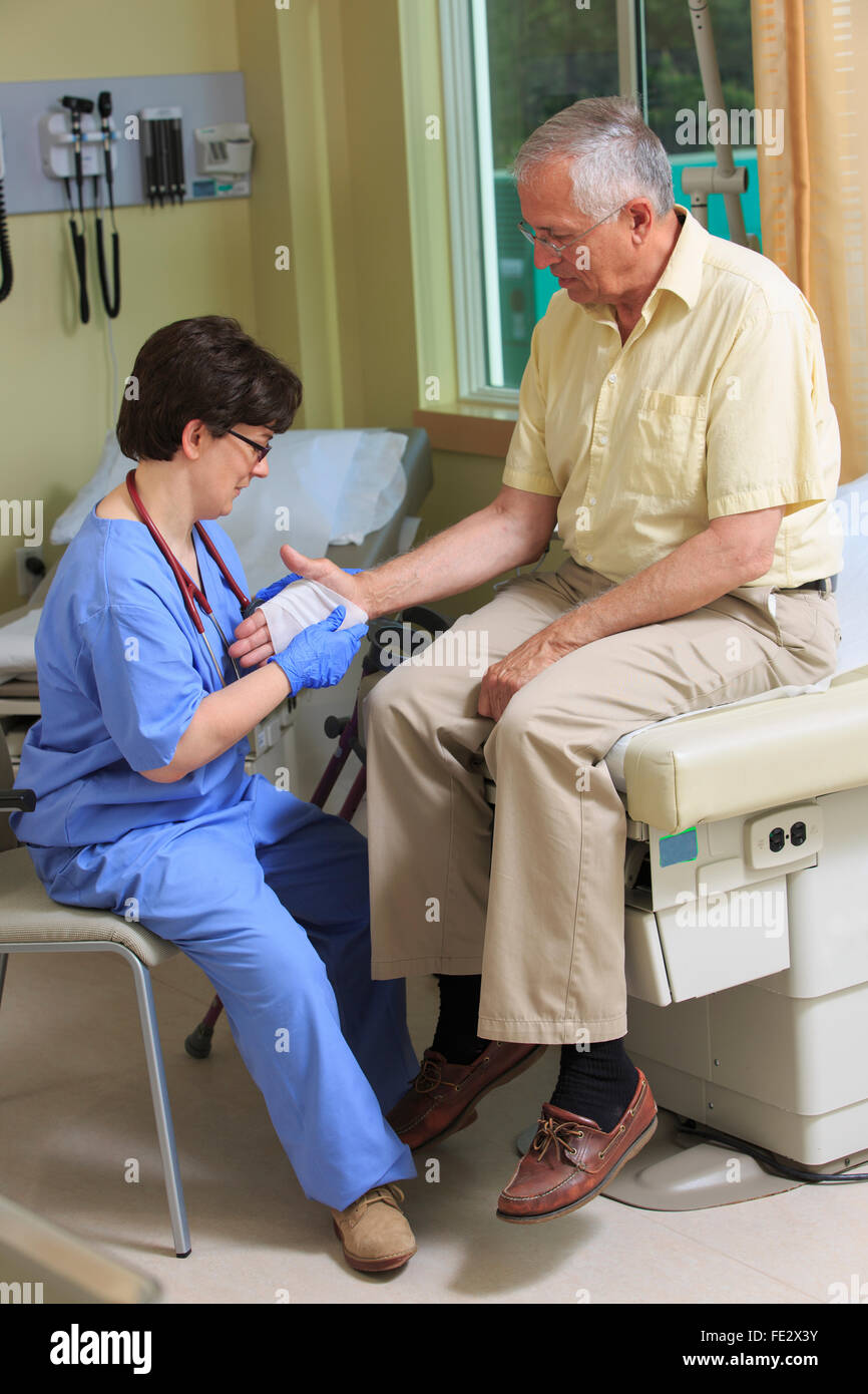 Infirmière avec la paralysie cérébrale liage de la main du patient dans une clinique Banque D'Images
