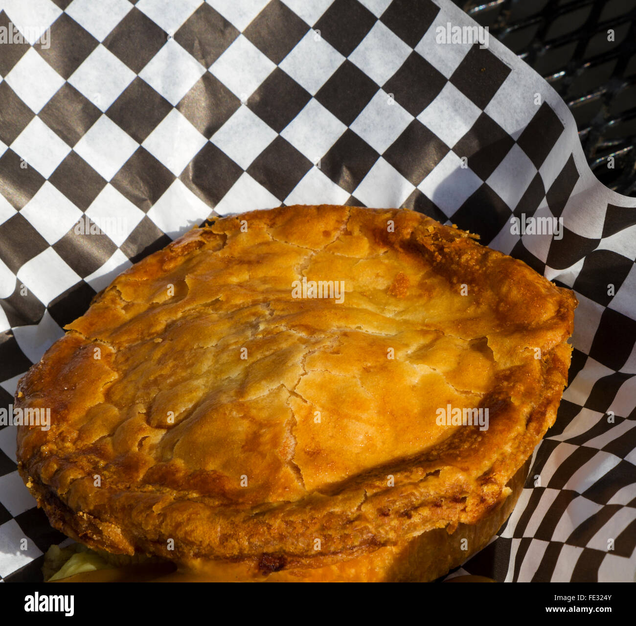 Tourte au poulet fraîchement cuits servis en plein air sur noir table de patio. Présentation informelle de confort alimentaire, chaud avec sauce suintantes Banque D'Images