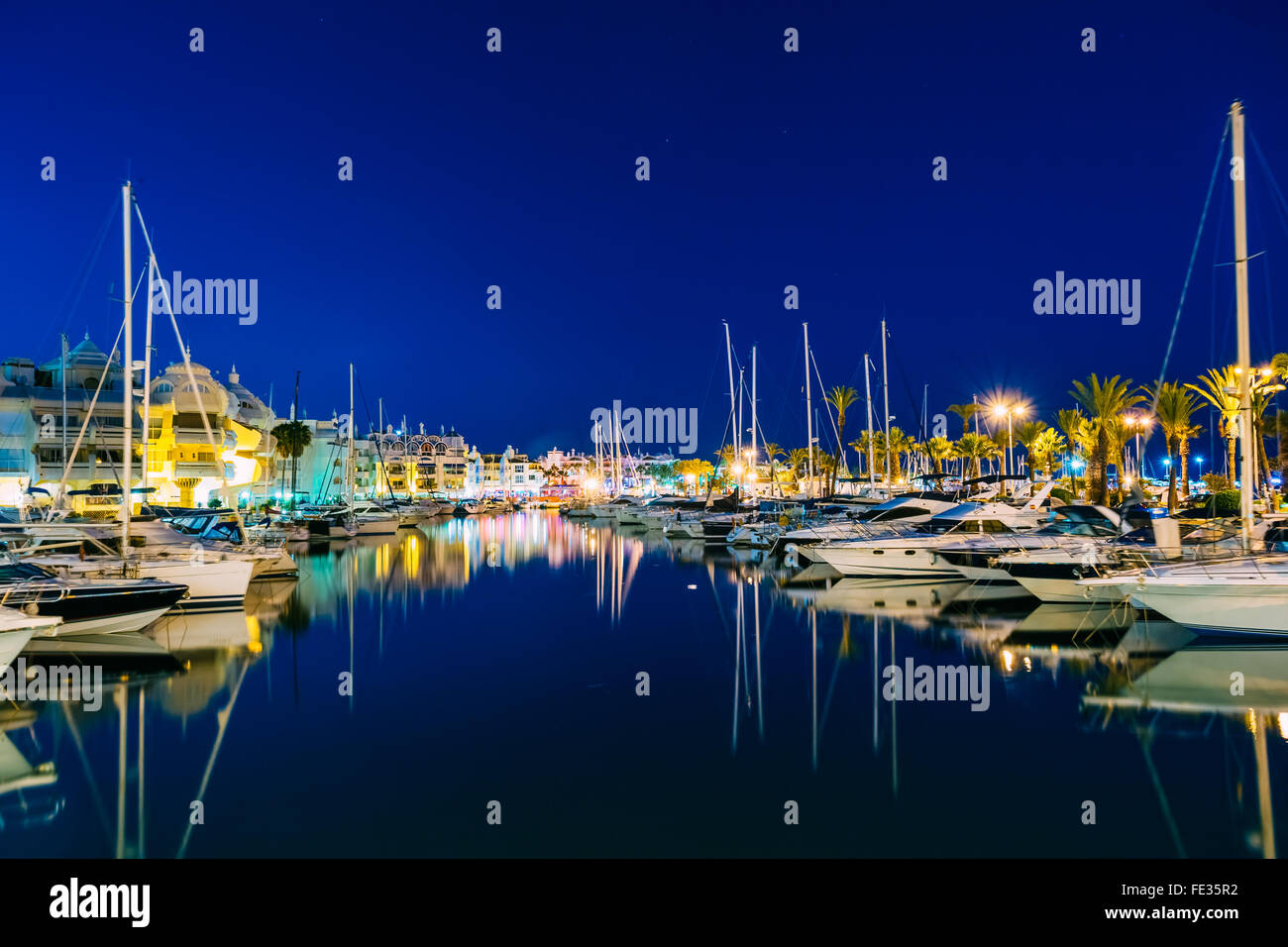 Vue panoramique de nuit de mouillage à Benalmadena. La surface de l'eau bleue fusionne avec ciel profond. Banque D'Images