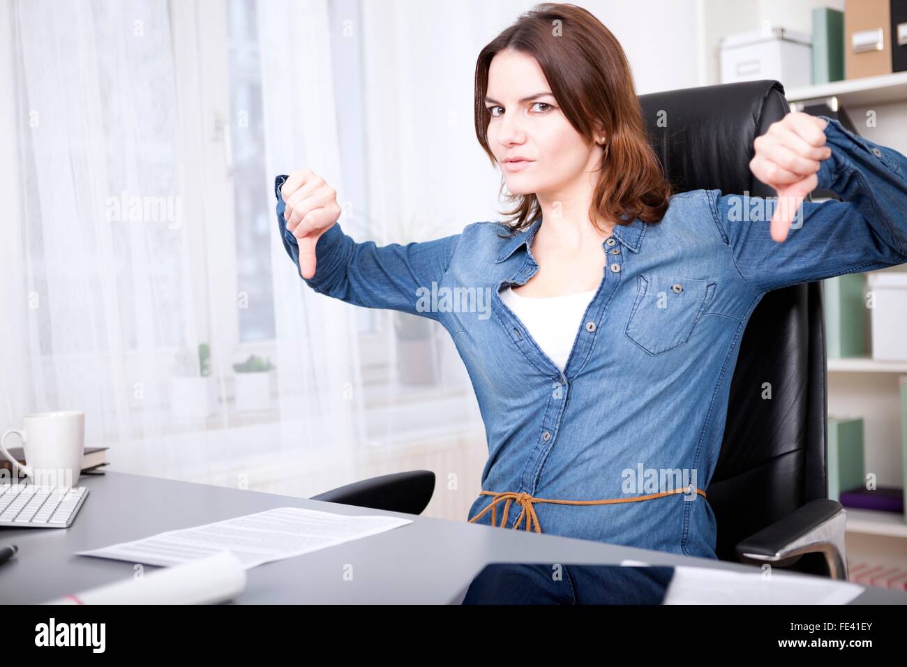 Businesswoman giving Thumbs down avec force geste avec les deux mains et les sourcils à l'appareil photo montrant la désapprobation, un échec Banque D'Images