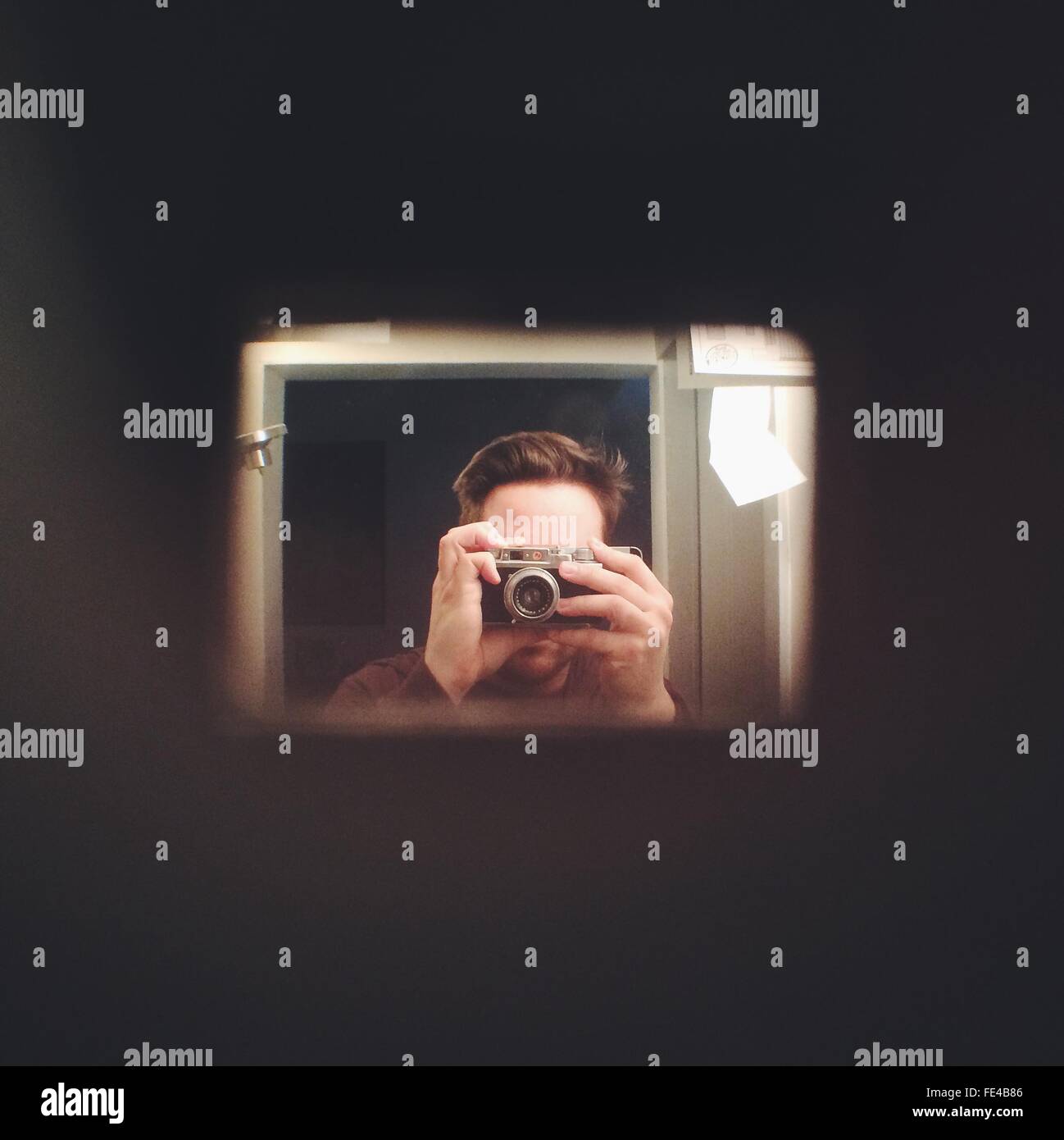 La réflexion de l'homme dans le miroir tout en photographiant Banque D'Images