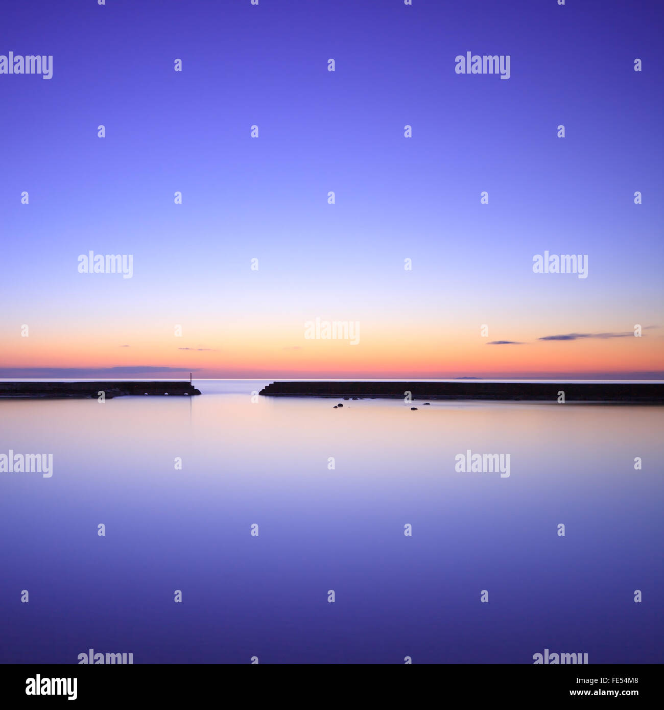 Jetée en béton ou silhouette jetée et océan bleu crépuscule sur le coucher du soleil. Banque D'Images