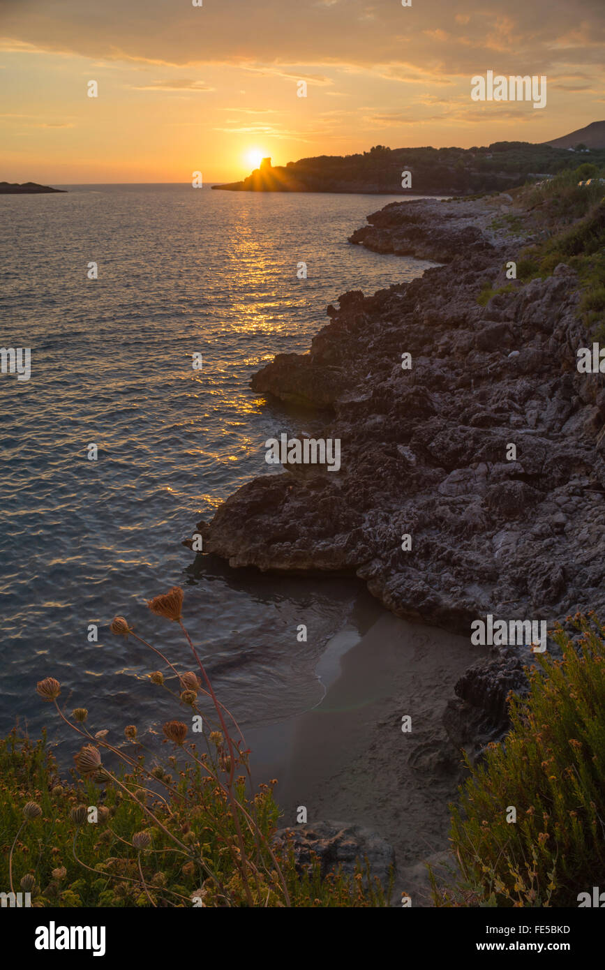 Golden coucher de soleil sur la mer Méditerranée et la côte rocheuse au centre de la ville de Marina di Camerota, Cilento, Campanie, Italie Banque D'Images