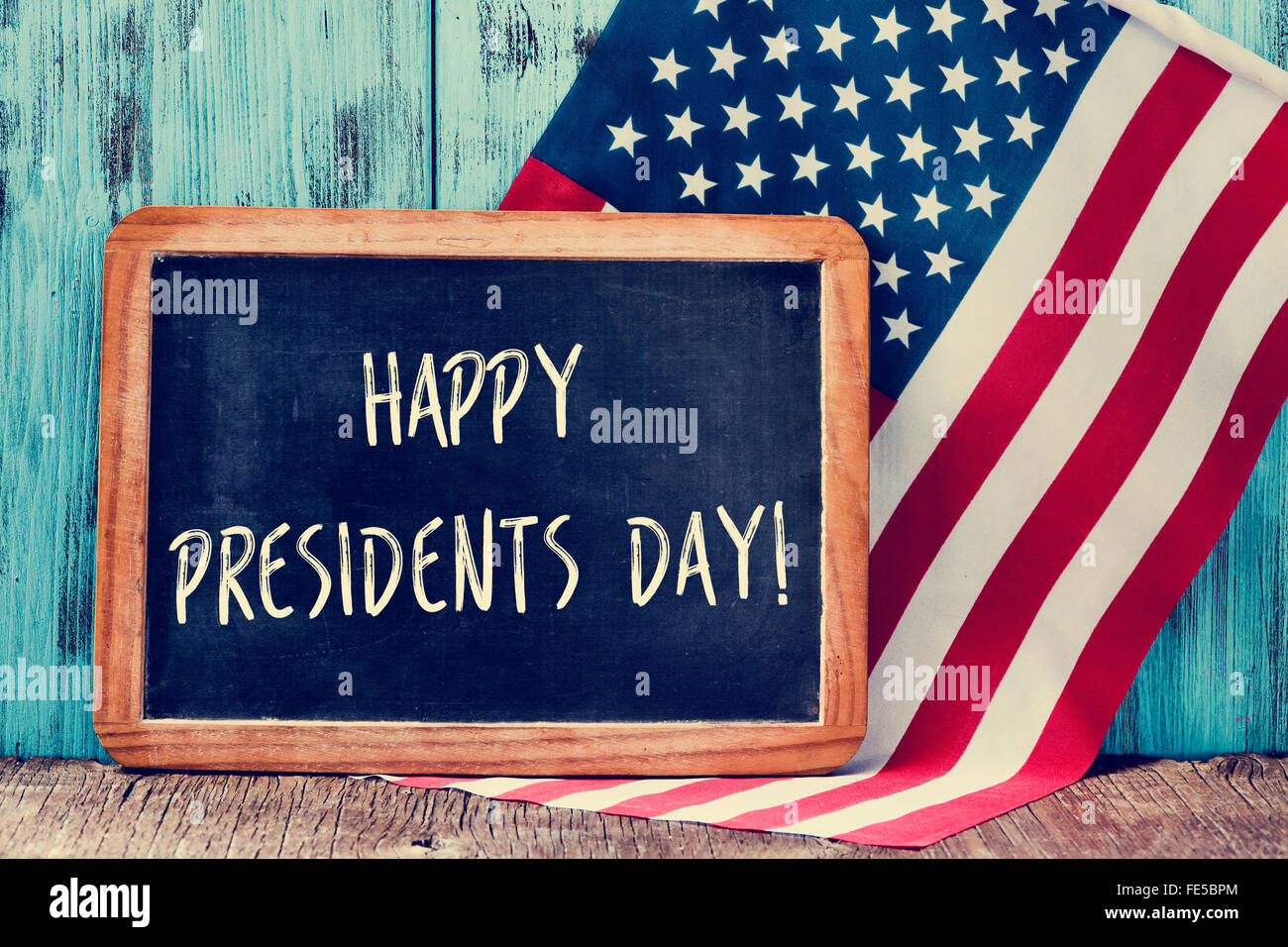 Le texte heureux présidents jour écrit dans un tableau noir et un drapeau des États-Unis, sur un fond de bois rustique Banque D'Images