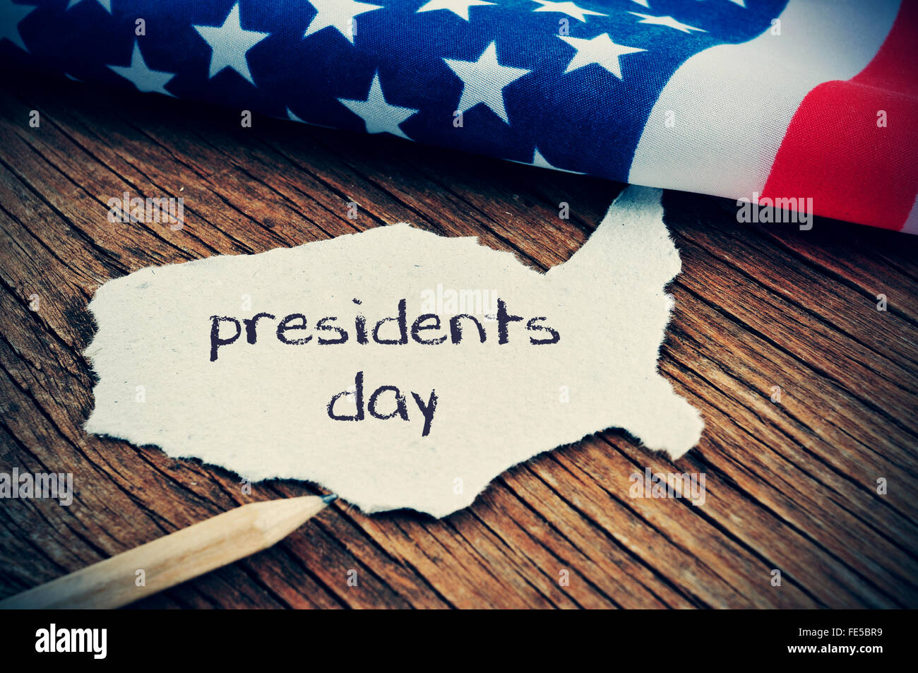 Un morceau de papier en forme de la United States avec le mot présidents jour écrit en C, placé sur un fond de bois nex Banque D'Images