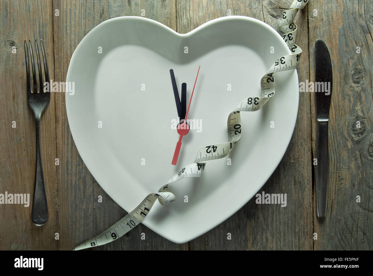 Plaque en forme de coeur avec des aiguilles d'horloge et ruban à mesurer Banque D'Images