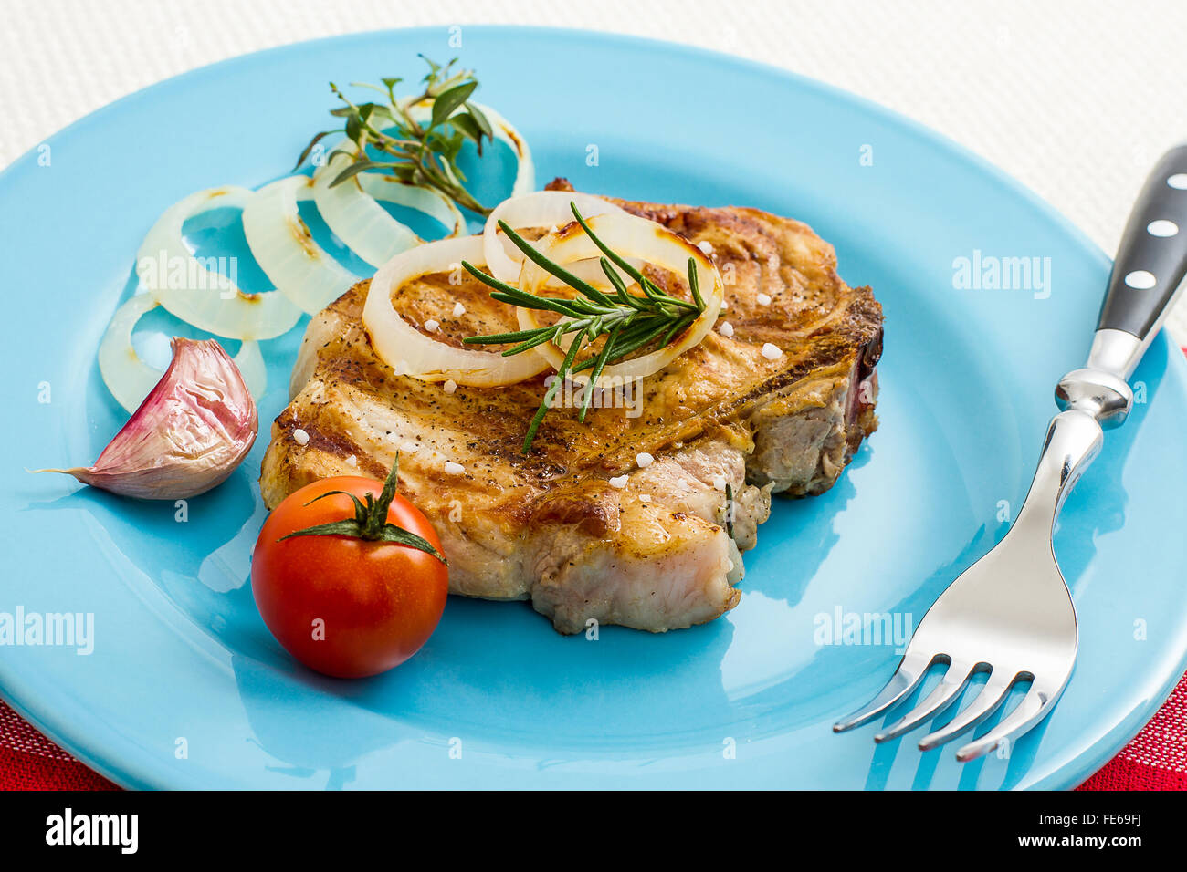 Côtelette de porc grillé juteux avec oignons et tomates, Close up Banque D'Images