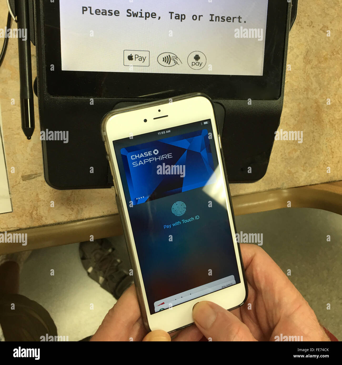 Un homme n'utilise que son pouce pour payer l'épicerie à l'aide d'Apple Payer avec Touch sur un IPhone 6S Plus en Californie du Sud. Banque D'Images