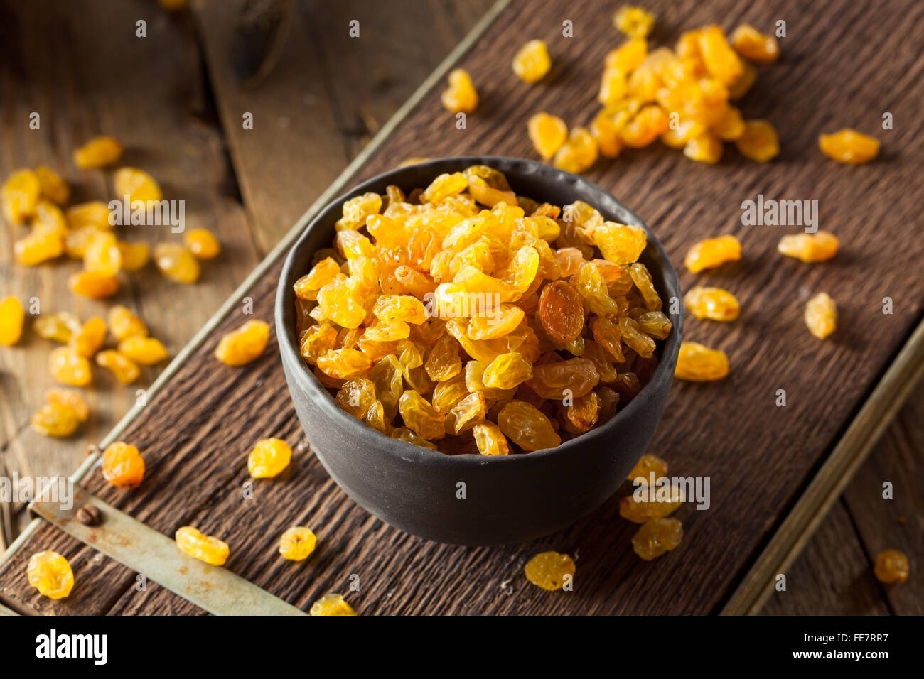 Séché bio Raisins secs dans un bol d'Or Banque D'Images