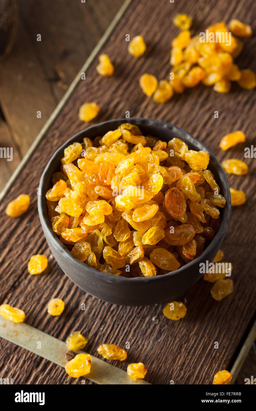 Séché bio Raisins secs dans un bol d'Or Banque D'Images