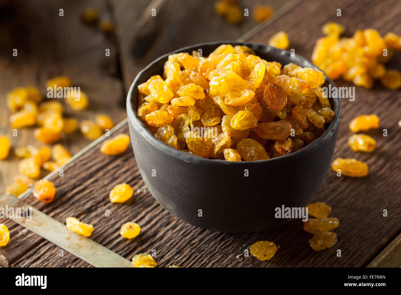 Séché bio Raisins secs dans un bol d'Or Banque D'Images