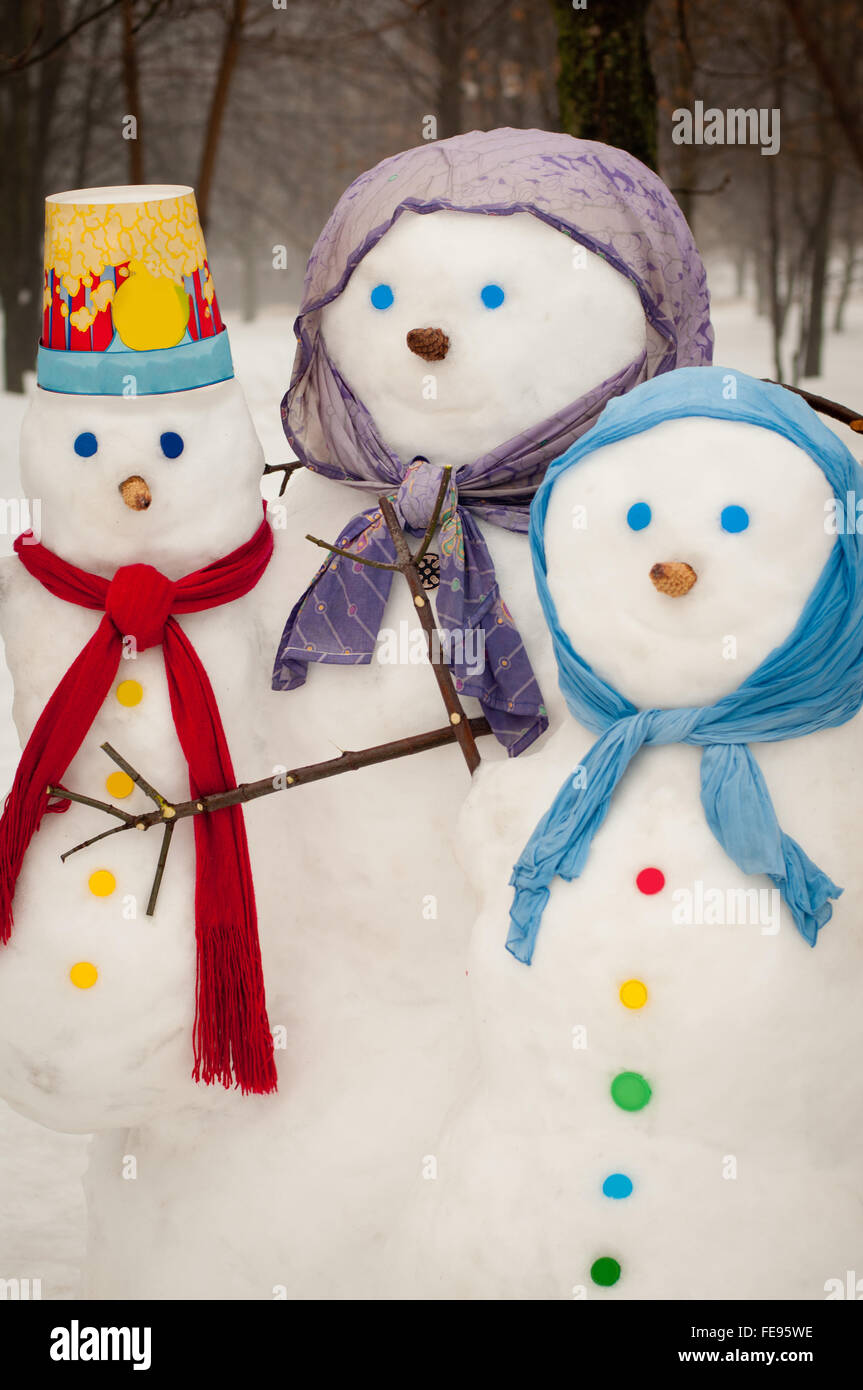 Trois bonhommes de neige en hiver en écharpe et chapeau Banque D'Images