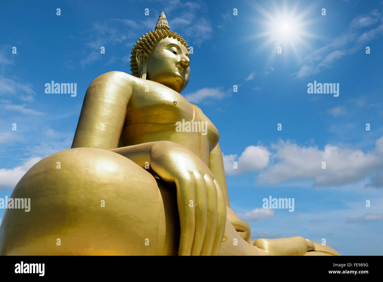 Statue de Bouddha en or isolé sur fond de ciel bleu. Banque D'Images