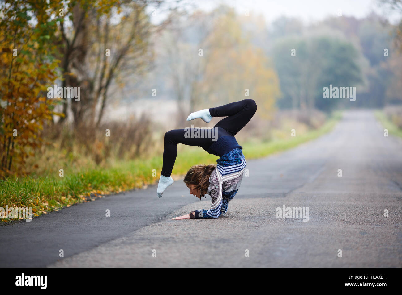 Jeune gymnaste professionnel rend se divise sur la route au moment de l'automne Banque D'Images