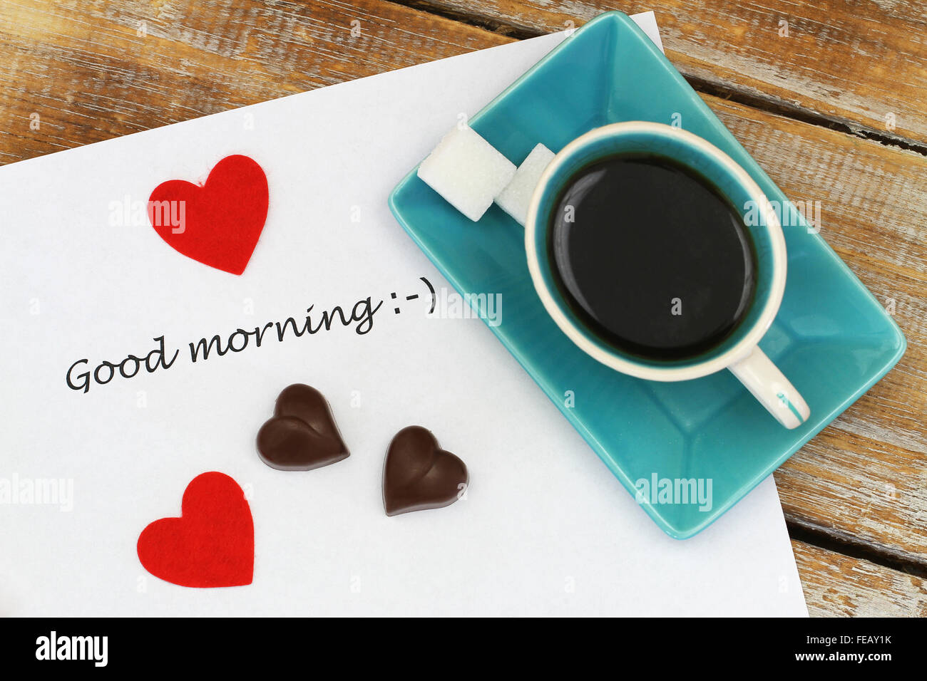 Bon matin, écrit sur papier blanc, en forme d'coeur chocolats et tasse de café noir Banque D'Images